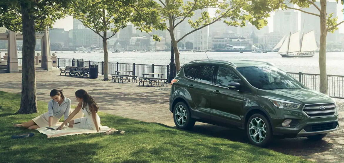 Image of a blue 2019 Ford Escape driving by a park.