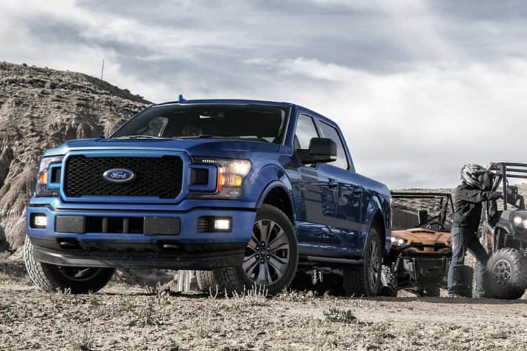 Image of a blue 2019 Ford F-150 driving on rough terrain