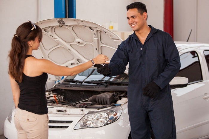 Image of a female customer getting her keys from a smiling mechanic.